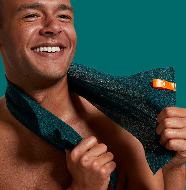 Man holding a green towel with a brand logo against a teal background